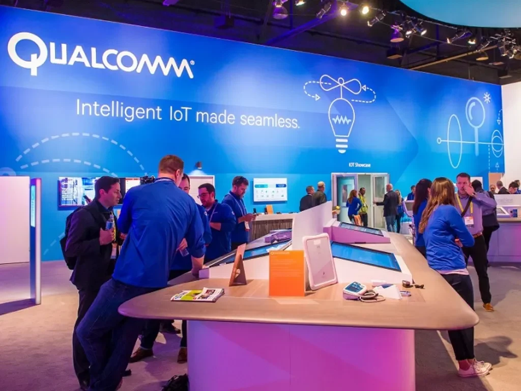 Visitors talking at a Qualcomm booth at a past CES